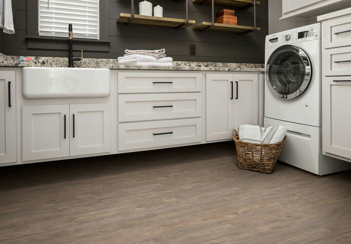 Bathroom and laundry room, luxury vinyl flooring, white cabinets, sink, basket of towels